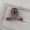 Nahaufnahme der Haarspange aus rosa Tweed mit glänzenden Pailletten und feiner Webstruktur - Kreuzschleifen-Stil / Rosa