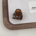 Detail shot of mini tortoiseshell hair claw clip made of amber resin on fabric background - Blue Brown Gradient