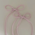 Detail von zwei rosa Schleifen-Haarspangen mit silbernen Entenschnabel-Clips aus Metall - Rosa