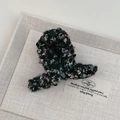 Détail d'une pince à cheveux en tweed noir à paillettes style français sur plateau gris - Style Boucle Croisée / Noir