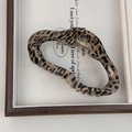 Dettaglio della pinza per capelli leopardata con texture lucida e molla in metallo dorato - Stile Nuvola