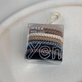 Macro detail of high-elastic braided hair ties in earth tones within a clear gift box - Black & Coffee