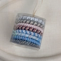 Detailansicht verschiedener gewebter elastischer Haargummis in einer tragbaren Box - Rosa und Blau Serie