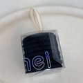 Detail von schwarzen elastischen Haargummis in einer klaren Box mit Seidenbandgriff - Schwarze Serie