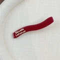 Barrette à cheveux ondulée rouge foncé avec lettrage doré Barrette LaFrance sur beige - Style Vague