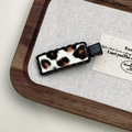 Close-up of leopard print hair clip with black wavy edges on rustic background - Black Leopard Rectangular