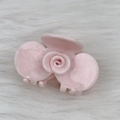 Detail view of the pink marble textured acetate rose flower hair claw clip on white fur - Pink