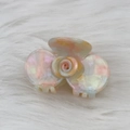 Macro shot of marble textured rose hair claw clip made of acetate on soft white background - AB Color