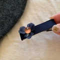 Dettaglio fermaglio per capelli a fiore in resina blu con perla arancione e raso blu - Base in Tessuto Blu
