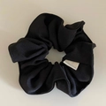 Primer plano del coletero de tela de sarga negra con diseño elástico y etiqueta blanca - Negro