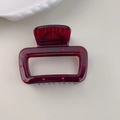 Detail view of a deep red rectangular hair claw clip with polka dot accents on a white surface - Large Square Style