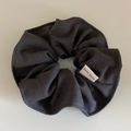 Detalle de un coletero de tela sarga gris oscuro con etiqueta blanca de Hand Made - gris oscuro