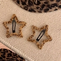 Macro detail of two leopard print plush star hair clips on a soft knitted background - Five-pointed Star