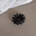 Elastic black spiral hair tie with glossy finish on a textured grey background - Black