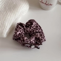 Detail van paarse scrunchie met luipaardprint, lederen strik en zilveren bedeltje - Haarelastiek