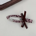 Detail van roze luipaard haarclip met France Handmade gravure en leren strik - Strikje Eendenbek Clip