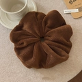 Κοντινή λήψη μεγάλου καφέ scrunchie από παχύ βελούδινο ύφασμα με υφή μαλλί προβάτου - Καφέ
