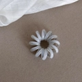 Elastic blue telephone cord hair tie with spiral design on a rustic textured background - Light Grey