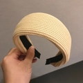 Detailed view of beige knitted headband with thick woven texture and black lining - Beige