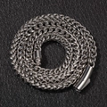 Macro detail of silver stainless steel Franco chain bracelet with cylindrical clasp - Franco Braided Style / Silver Necklace