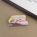 Dettaglio della molletta per capelli angelo dormiente con ali in acetato rosa e giallo - Angelo