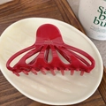Detail of red glossy acetate hair claw with gold France Handmade logo on ceramic plate - Red