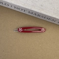 Détail de la barrette ovale en acétate bordeaux avec strass et lettrage doré élégant - Bordeaux