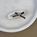 Detail einer weißen Perlen-Haarklammer mit brauner Seifenschleife und Herzanhänger - Entenschnabel-Haarclips