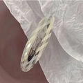 Detail view of the diamond-cut faceted oval acetate hair clip on a minimalist background - Iridescent Translucent White