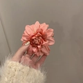 Dettaglio ravvicinato di una pinza per capelli con camelia rosa e petali - Grande