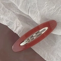 Detailed macro view of an oval burgundy acetate hair clip with Barrette La France lettering - Watermelon red