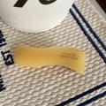 Dettaglio del fermaglio giallo ondulato con la scritta France Handmade incisa - Giallo