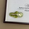 Detail of a wavy green marble acetate hair clip with a gold metal duckbill fastener - Green