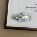 Detailed close-up of cloud-shaped acetate hair clip with iridescent marble texture finish - Blue Pink