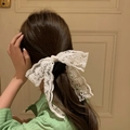 White floral lace scrunchie with long ribbon bow shown on a female hairstyle - White Lace Scrunchie