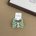 Detail view of two light green floral print fabric bow hair ties on a display card - Floral Hair Tie Style