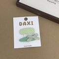 Detail of two-piece green floral bow hair clips set on a handmade display card - Plaid Oval Style
