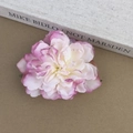 Vue détaillée d'une pince à cheveux pivoine rose réaliste posée sur un livre - Dégradé Violet Blanc