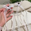 Detailansicht der weißen Spitzen-Haarspangen mit rosa Band und eleganten langen Quasten - Rosa