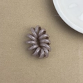 Détail d'un chouchou spirale flexible en résine de couleur gris-violet mat doux - Marron