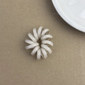 Détail d'un élastique spirale translucide blanc crème sur un fond en papier kraft - Khaki Clair
