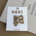 Detail of handmade khaki corduroy bow hair clips on a white display card with prop book - Corduroy Ribbed Satin Hair Clip Set (No. 8)