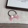 Detail of pink resin bow hair tie with hollow petal patterns and high elastic black band - Pink
