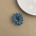 Élastique cheveux spirale bleu en résine durable posé sur un support papier marron - Bleu sarcelle