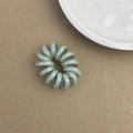 Élastique à cheveux spirale vert menthe translucide sur un fond de papier naturel - Vert Clair