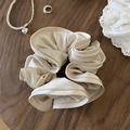 Elegant beige satin scrunchie with soft sheen on a vintage dark wood table background - Off-white