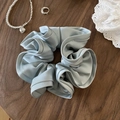 Elegant light blue satin scrunchie with soft pleats on a dark wood background - Light Blue