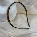 Dettaglio di cerchietto sottile tartarugato blu e marrone con denti interni antiscivolo - Sfumatura blu marrone