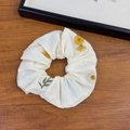 Dettaglio dell'elastico scrunchie in tessuto bianco con ricamo di margherite - Elastico per Capelli Ricamato