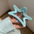 Nahaufnahme einer mintblauen Haarklammer in Sternform mit mattem Harz-Finish - Milchblau Stern Haarklammer